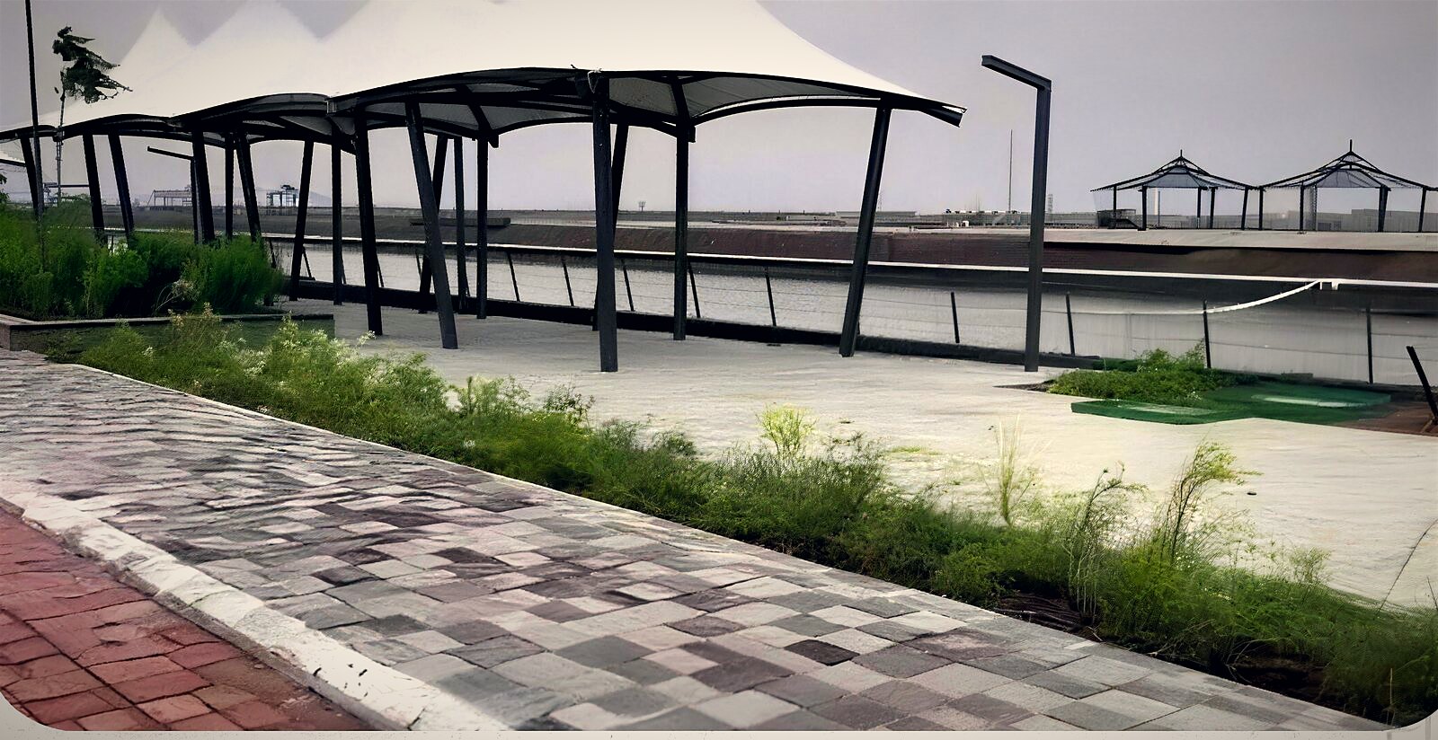 Photograph of the part built canal front in Dholera with walkways and shade pavilions