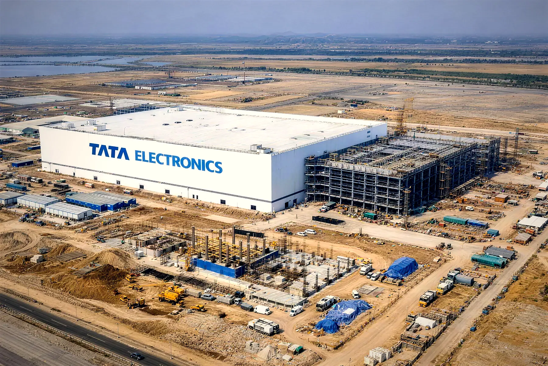 Aerial photo of the Tata Electronics semiconductor fab at Dholera, the main building up and steel frames rising beside it